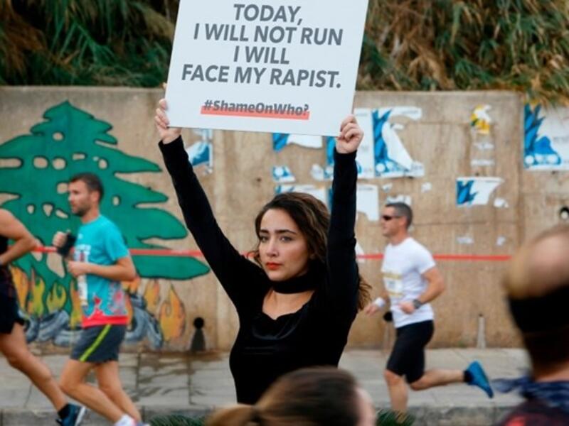 A protester holds a banner with a message against sexual assault during the 16th edition of the Beirut Marathon in the Lebanese capital on November 11, 2018. (AFP / Abaad / Marwan TAHTAH)
