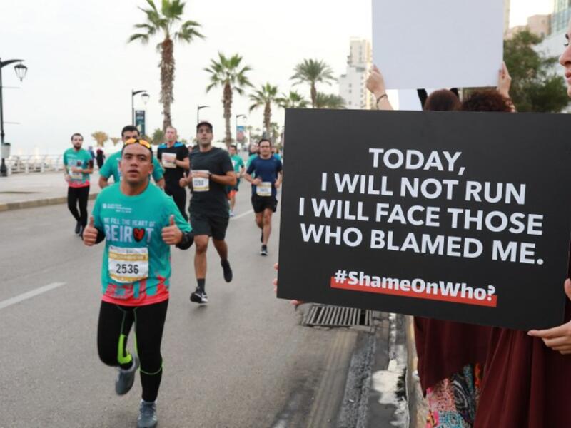 Activist holds a banner against sexual assaults during the 16th edition of the Beirut Marathon on November 11, 2018. 
ANWAR AMRO / AFP