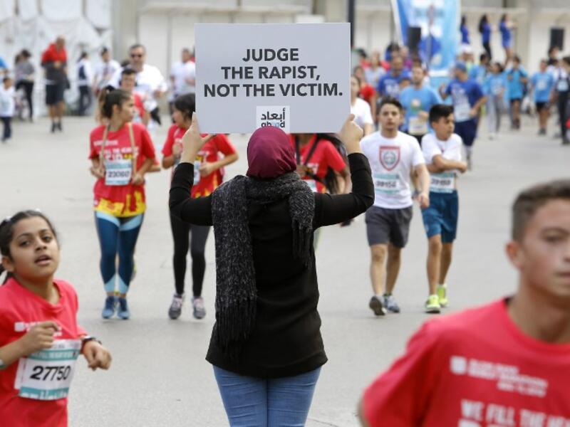 A protester holds a banner with a message against sexual assault during the 16th edition of the Beirut Marathon in the Lebanese capital on November 11, 2018. 
Marwan TAHTAH / Abaad / AFP