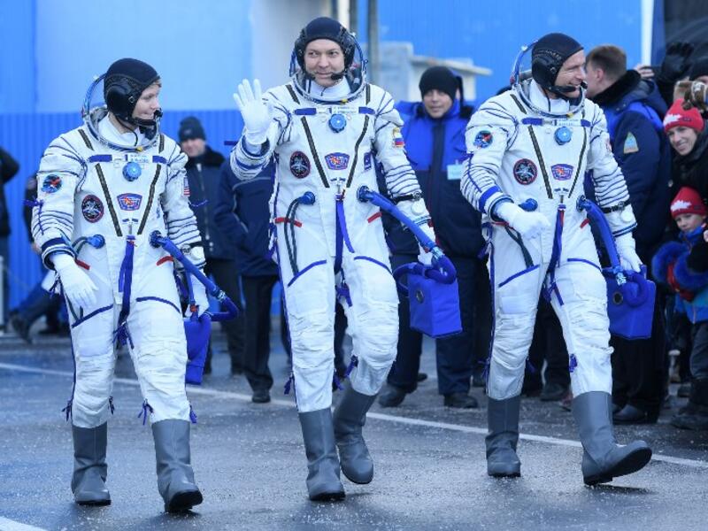 Members of the International Space Station (ISS) expedition 58/59, walk to report to Dmitry Rogozin (unseen), the head of the Russian space agency Roscosmos, prior to the launch onboard the Soyuz MS-11 spacecraft at the Russian-leased Baikonur cosmodrome in Kazakhstan on December 3, 2018. 
Kirill KUDRYAVTSEV / POOL / AFP