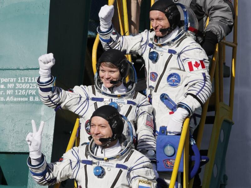 Top-bottom: Members of the International Space Station (ISS) expedition 58/59, gesture as they board the Soyuz MS-11 spacecraft shortly before the launch at the Russian-leased Baikonur cosmodrome in Kazakhstan on December 3, 2018. 
Shamil ZHUMATOV / POOL / AFP