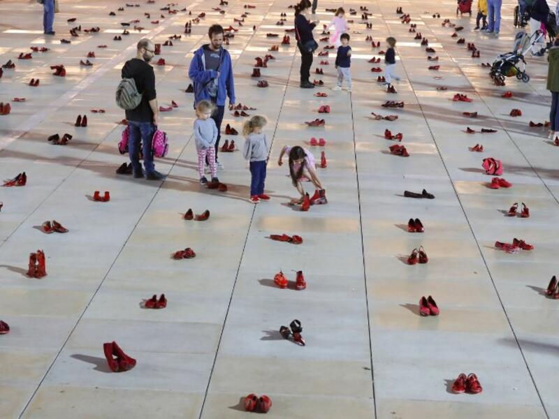 Israelis walk past an installation of red shoes during a rally against domestic violence in the Israeli coastal city of Tel Aviv on December 4, 2018. JACK GUEZ / AFP