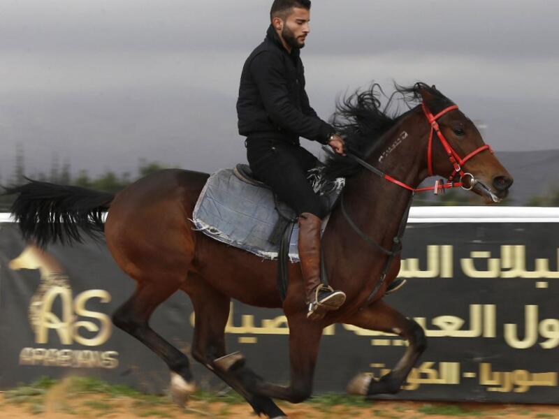 A Syrian man rides a horse at a track in the town of Dimas, west of the Syrian capital Damascus LOUAI BESHARA / AFP