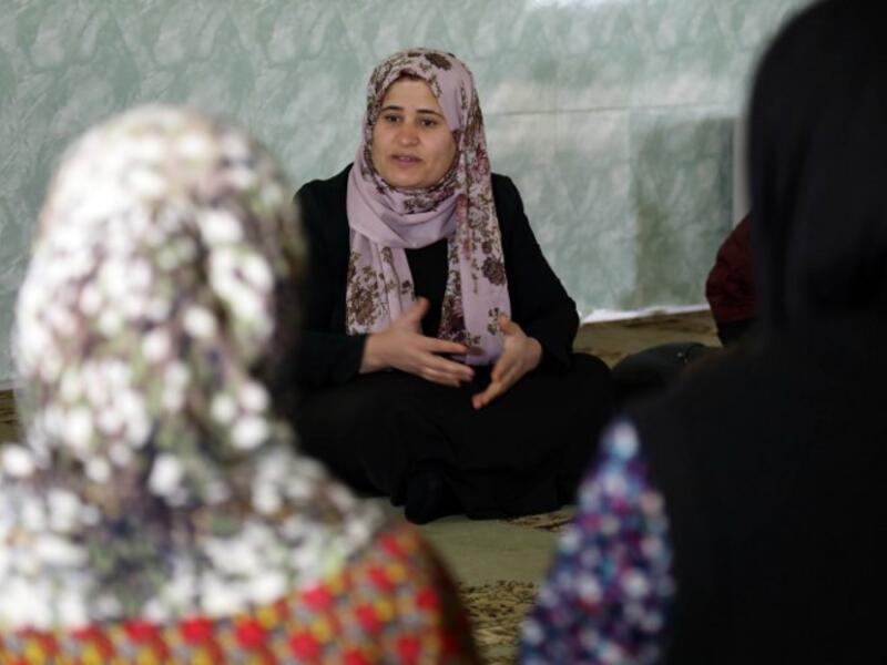 Rasul (C), an Iraqi Kurdish activist with the non-profit organisation WADI, speaks to women and young girls about the harms of genital mutilation in Sharboty Saghira.
SAFIN HAMED / AFP