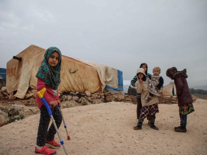 Syrian Maya Merhi poses for a picture next to her prosthetic legs that are decorated with the Turkish flag inside a tent at the Internally Displaced Persons (IDP) camp of Serjilla in northwestern Syria. 
Aaref WATAD / AFP