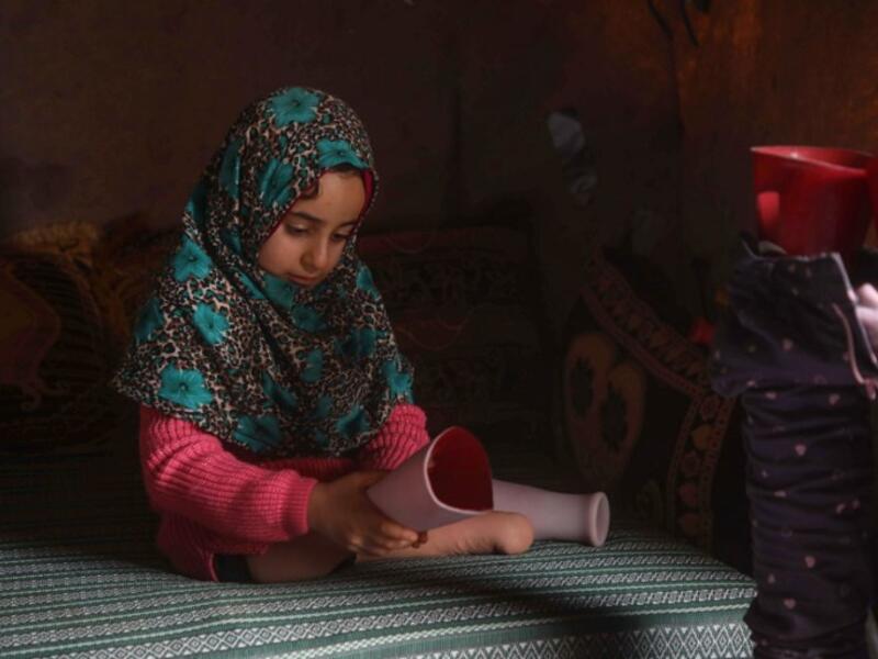 Syrian Maya Merhi poses for a picture next to her prosthetic legs that are decorated with the Turkish flag inside a tent at the Internally Displaced Persons (IDP) camp of Serjilla in northwestern Syria. 
Aaref WATAD / AFP