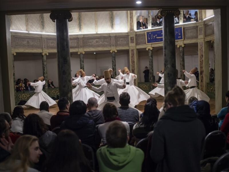 People look at whirling dervishes performing during a ceremony marking the anniversary of the death of Jelaleddin Mevlana Rumi, Sufi mystic, poet and founder of the sufism on December 16, 2018 at Galata Mevlihanesi in Istanbul. 
Yasin AKGUL / AFP