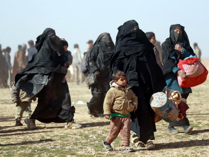 People who fled battles between Syrian Democratic Forces (SDF) and ISIS fighters in the Syrian village of Baghouz, arrive after crossing a desert in the back of a truck to a region controlled by the SFD in the countryside of the Deir Ezzor province. Delil SOULEIMAN / AFP