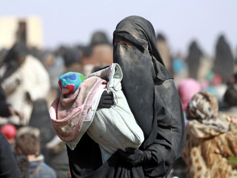 People who fled battles between Syrian Democratic Forces (SDF) and ISIS fighters in the Syrian village of Baghouz, arrive after crossing a desert in the back of a truck to a region controlled by the SFD in the countryside of the Deir Ezzor province. Delil SOULEIMAN / AFP