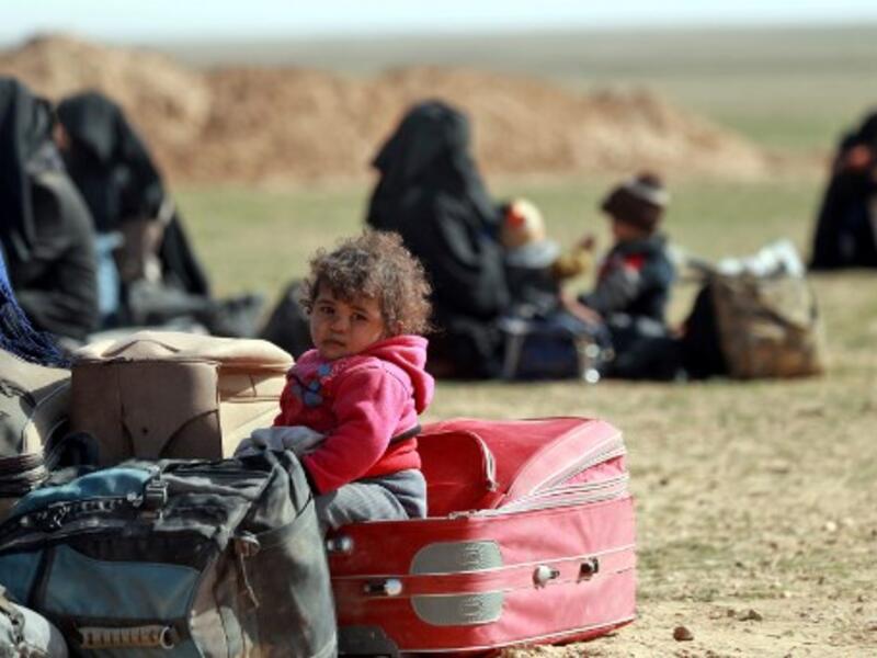 People who fled battles between Syrian Democratic Forces (SDF) and ISIS fighters in the Syrian village of Baghouz, arrive after crossing a desert in the back of a truck to a region controlled by the SFD in the countryside of the Deir Ezzor province. Delil SOULEIMAN / AFP