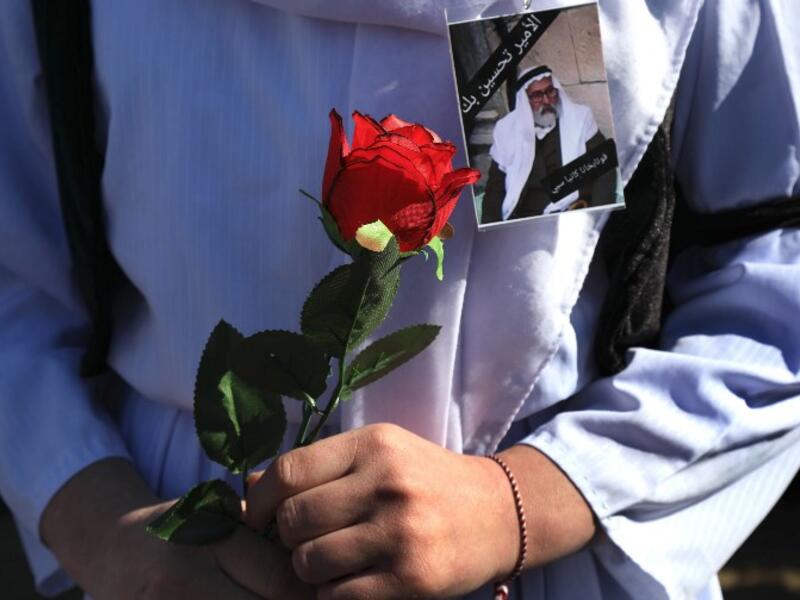 An Iraqi Yazidi carries a rose during the funeral of the Mir Takhsin-Beg (Tahseen Said Ali), the hereditary leader of the Yazidi community in the world, in the town of Sheikhan, 50km northeast of Mosul. 
SAFIN HAMED / AFP