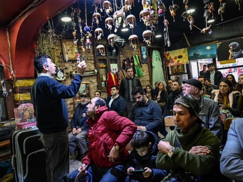 An auctioneer shows items to the audience at an auction house in Istanbul's Balat district.
OZAN KOSE / AFP