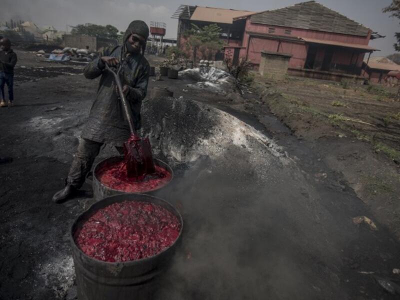 A young man boils cow blood before the sun-drying process to make fertiliser at Kaduna Abatour meat market in North Kaduna CRISTINA ALDEHUELA / AFP