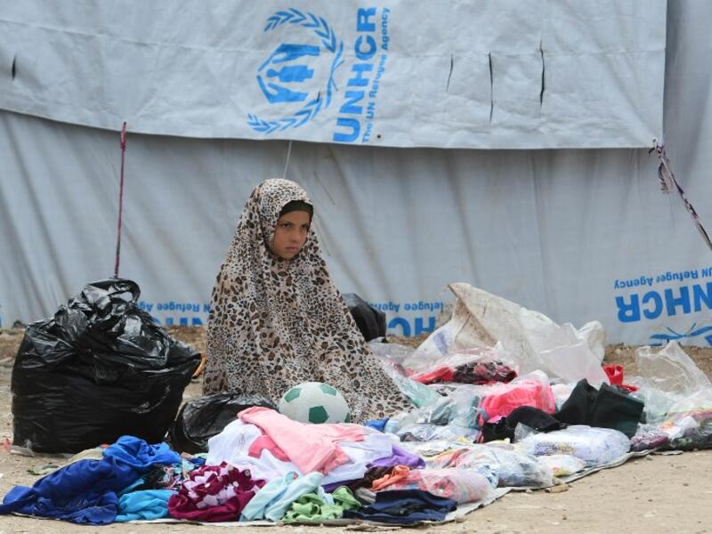A displaced girls sells second hand items  in the souk or market of Al-Hol camp for displaced people in northeastern Syria 
GIUSEPPE CACACE / AFP