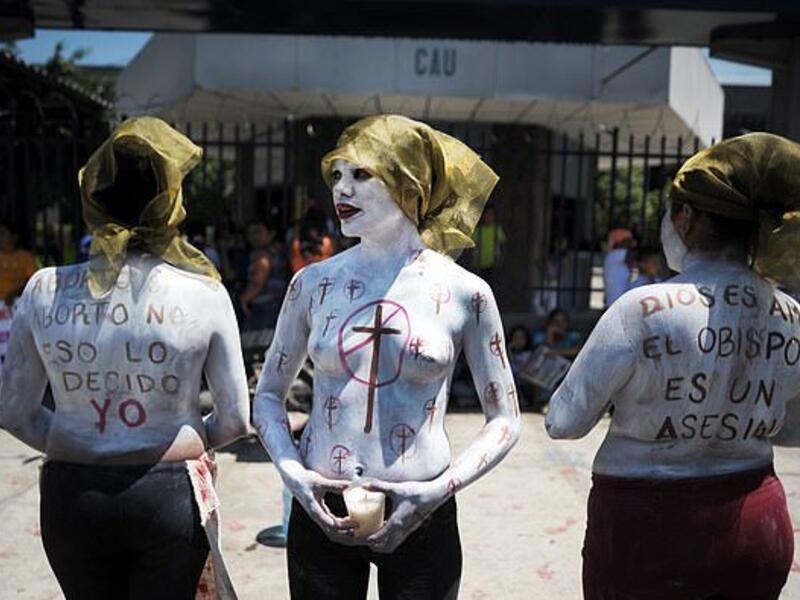Imelda Cortez, 20, is facing 20 years in jail after she was charged with attempted murder for giving birth to her abuser's baby in a toilet in El Salvador. Pictured: Members of a feminist organisation demonstrate in favour of abortion rights outside the Courthouse of San Salvador  (AFP)