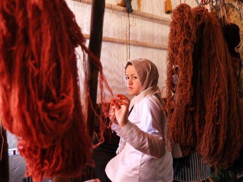 Afghan girls learn the skills to weave rugs at a small factory in the Enjil district of Herat Province (Rezayee/Twitter)