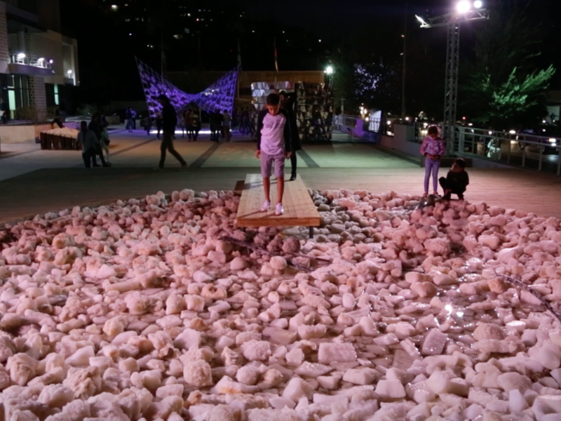 A boy stares down at his faint reflection in the salty water barely surfacing amongst a pond of rocks. A project by architect and urban designer representing the condition of the new ‘dry’ Dead Sea.  (Al Bawaba/Salim Essaid) 