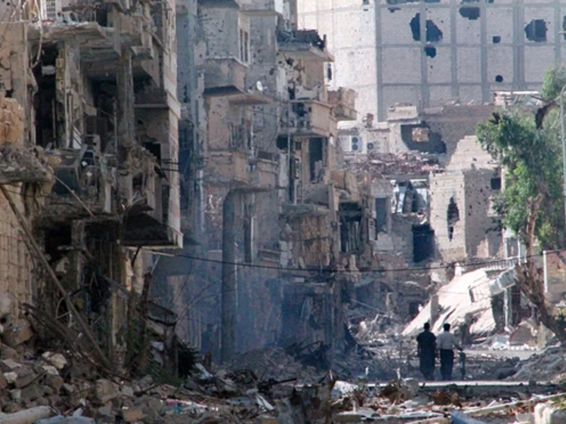 Two people walk through a destroyed neighborhood in Deir Ezzor. (AFP/Ahmad Aboud)