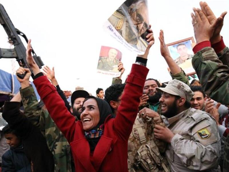 The Military Strongman:

After another brief spell in the US, Haftar returned to Libya and announced that the General National Congress, the country’s elected authority, had been dissolved. Those who opposed him described this as a coup attempt, however he denied the allegation.

(Photo: A woman waves a picture of Haftar. AFP)
