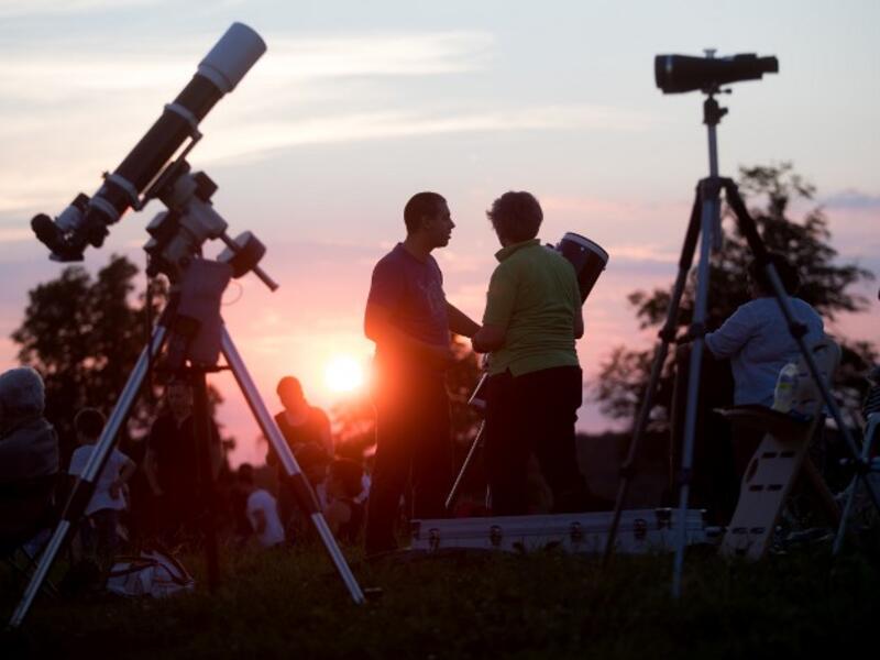 People gather as they wait for the sun to go down and the appearance of the 'Blood moon' in Vienna, Austria on July 27, 2018. The 'Blood moon' total lunar eclipse, is the longest of the 21st century.
GEORG HOCHMUTH / APA / AFP