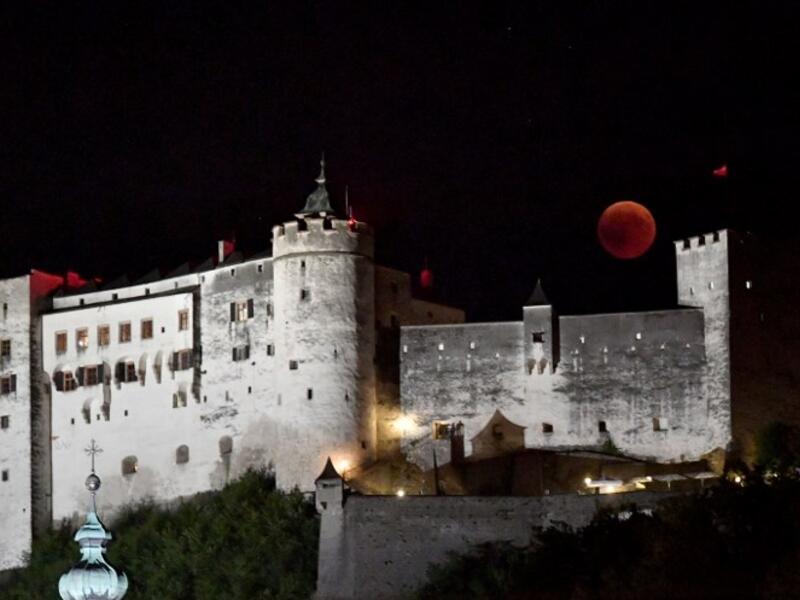 This picture shows the full moon during a 'blood moon' eclipse over the Festung Hohensalzburg castle in Salzburg on July 27, 2018. (AFP/APA/ BARBARA GINDL)
