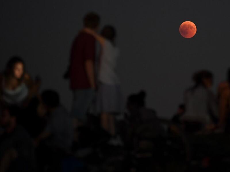 People watch the total lunar eclipse in the Olympic park in Munich, southern Germany, on July 27, 2018. (AFP, CHRISTOF STACHE)