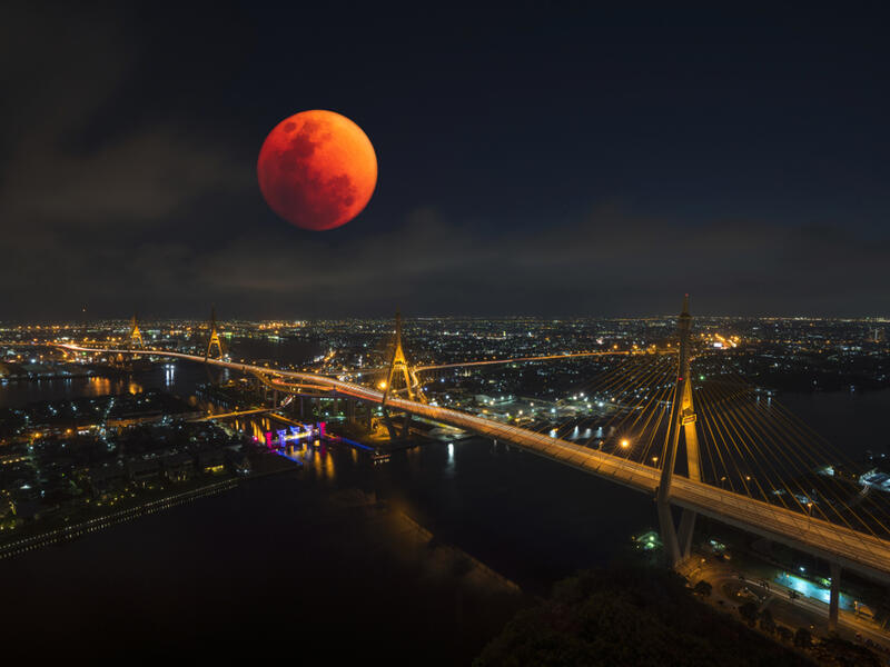 Lunar eclipse, super blood moon with view of the Bhumibol bridge and Curve of Chao Phraya River in Bangkok (Shutterstock)