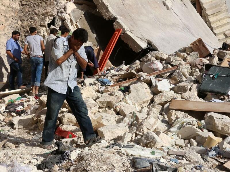 A Syrian man reacts as rescuers look for victims under the rubble of a collapsed building following a reported air strike in Aleppo on July 19, 2016 (AFP/Thaer Mohammed)