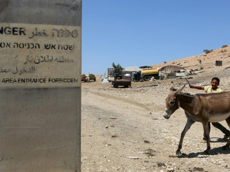 A sign on a concrete block reads "Firing area entrance forbidden" in Hebrew, Arabic and English (AFP/Jaafar Ashtiyeh)