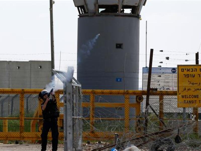 An Israeli soldier fires tear gas canisters towards Palestinian protesters outside the compound of the Israeli-run Ofer prison, in the occupied West Bank. (AFP/File)  