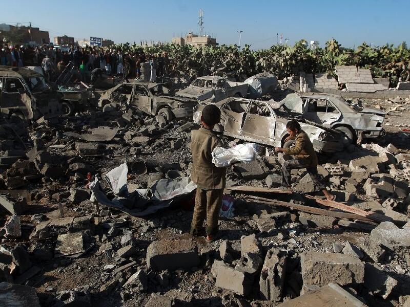 Yemenis stand at the site of a Saudi air strike against Huthi rebels near Sanaa Airport on March 26, 2015 (AFP/Mohammed Huwais)
