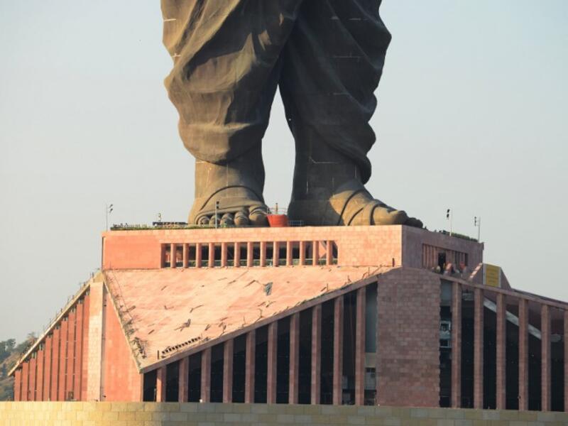 Indian construction workers are seen at the plimth structure the "Statue Of Unity". (SAM PANTHAKY / AFP)