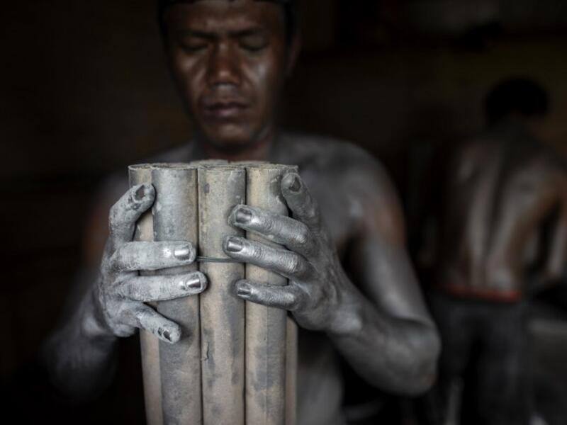 Workers covered with gunpowder material make fireworks for New Year celebrations in Bocaue, Bulacan, north of Manila on December 26, 2018. 
Noel CELIS / AFP