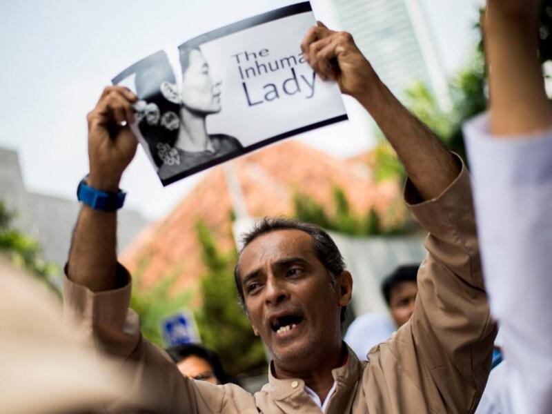 An Indonesian protester tears a picture of Aung San Suu Kyi during a rally in front of Myanmar embassy in Jakarta on September 2, 2017 (AFP)