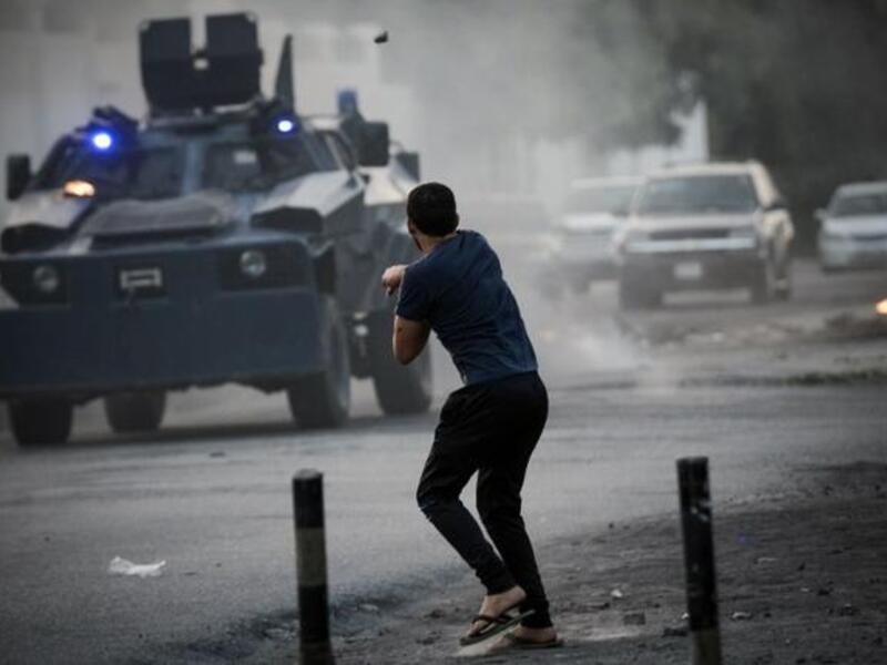 A Bahraini demonstrator hurls a rock towards riot police during clashes following the funeral of Hussein Abdullah, in the village of Saar, west of Manama, on June 26 (AFP)