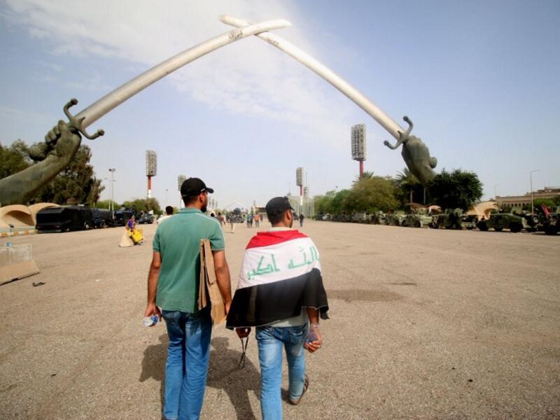 Two Sadrist protesters walk through Baghdad's Green Zone, after a weekend of protests and sit-ins demanding parliamentary change (AFP/Haidar Mohammed Ali)