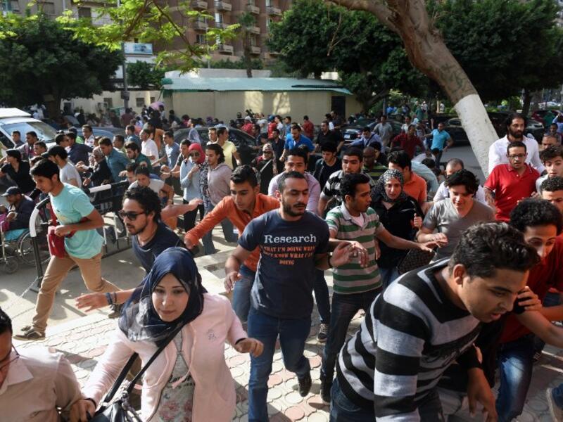 Protesters run from tear gas in Cairo on April 25. (AFP/Mohamed El-Shahed)
