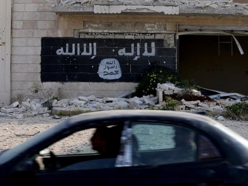 A Daesh slogan painted on the wall of an abandoned factory. (AFP/File)