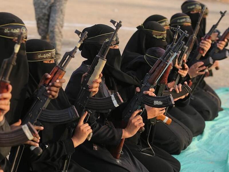 The women of the al-Quds Brigades holding Kalashnikov rifles and poised for action during the exercise at Khan Yunis on the southern section of the Gaza Strip (APA/Shutterstock)