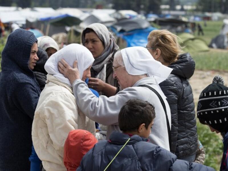 A nun talks to a woman at a makeshift camp for migrants and refugees near the village of Idomeni not far from the Greek-Macedonian border on May 4, 2016. (AFP/Tobias Schwarz)