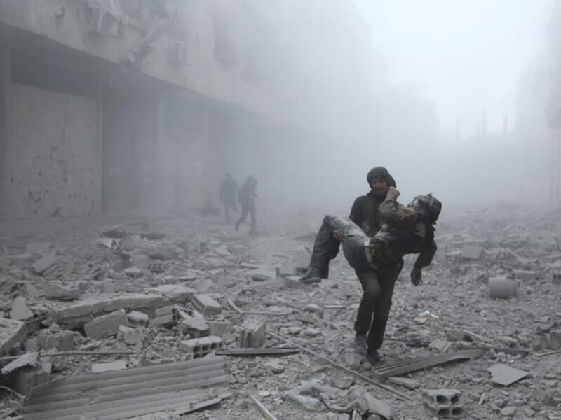 A wounded man is carried following an air strike on the rebel-held town of Erbin in Eastern Ghouta near Damascus on January 2, 2018 ABDULMONAM EASSA/AFP/FILE