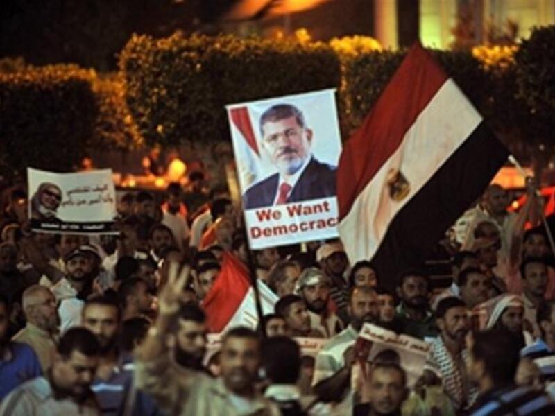 Egyptian supporters of the deposed president Mohamed Morsi hold his portrait and wave the national flags during a demonstration against the government in Cairo on July 31, 2013 ( FAYEZ NURELDINE/AFP/Getty Images)
