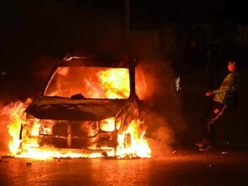 A boy kicks a burning car in Cairo on Friday as violent protests erupted between the police and those who oppose Mohamed Morsi's regime