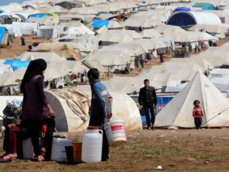 Syrian refugees filling their buckets at Atmeh refugee camp, in the northern Syrian province of Idlib, Syria, Apr. 5, 2013. [Getty Images]