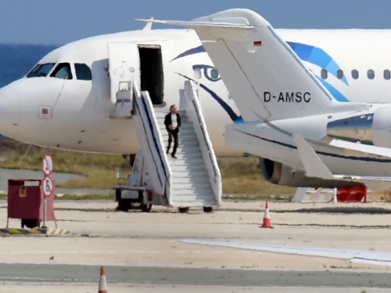 The alleged hijacker disembarks before surrendering to security forces after a six-hour standoff on the tarmac at Larnaca airport's largely disused old terminal on March 29, 2016. (AFP/George Michael)