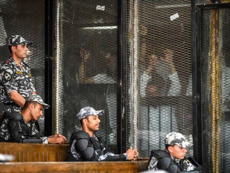 Members of Egypt's banned Muslim Brotherhood are seen inside a glass dock during their trial in the capital Cairo on July 28, 2018. (AFP/Khaled Desouki)
