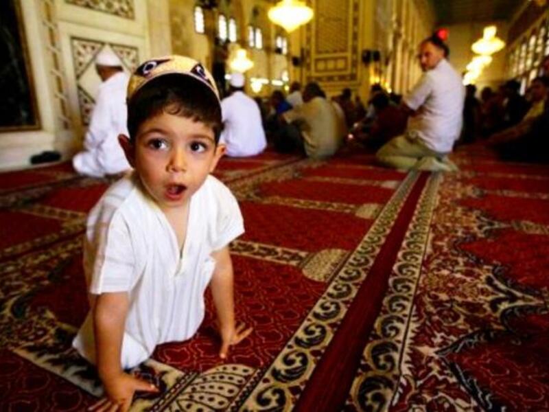 Syria, Damascus: Hoping for a peaceful religious festival away from the wider Syrian turmoil this Eid, a Syrian Muslim boy attends the weekly Friday prayer at the Omayyad Mosque in central Damascus.