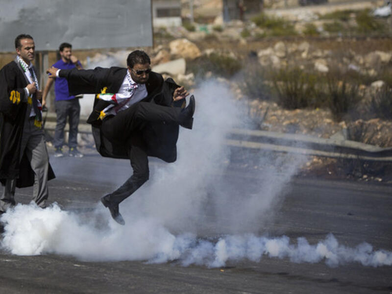 palestinian lawyer kicks tear gas can