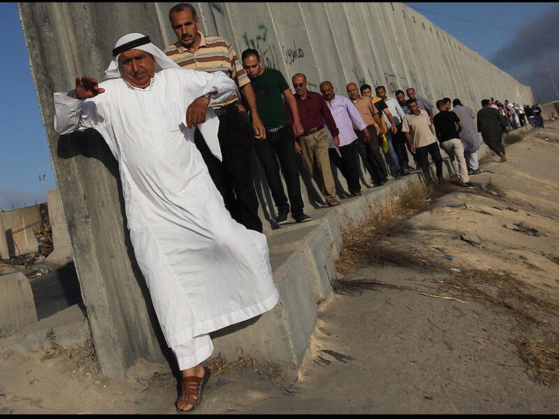 palestinians queue at israeli checkpoint