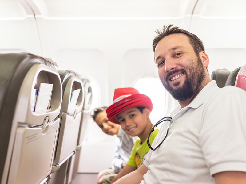 Arab man and kids plane seats looking up